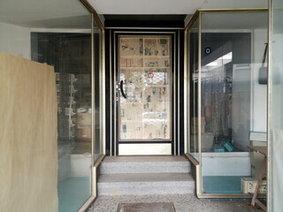 Mit Zeitung verklebte Ladentür eines geschlossenen Geschäft mit leerem Schaufenster in der...