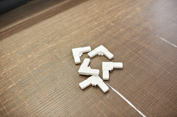 Connecting fasteners for mosquito net profiles are laid out on a wooden table.