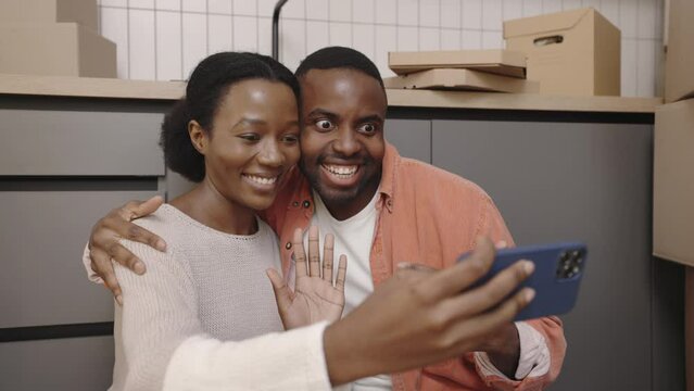 African american couple happily making selfie in their new home. Modern communication and relocation concept.