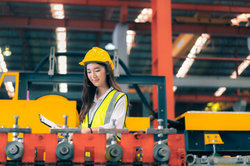 Fototapeta na wymiar Happy professional beautiful Asian woman industrial engineer/worker/technician with safety hardhat use clipboard to inspect quality control of machinery in production steel manufacture factory plant