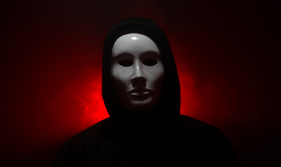 Man wearing mask with hoodie on red background.