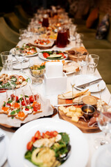 traditional Spanish or Italian tapas. jamon iberico, blue cheese, crackers, olives, grapes and dry red wine, grey stone background. Top view