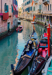 Fototapeta na wymiar Gandolas and small boats in Venice's inner canal. Italy, 2019