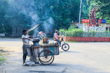 A peanut seller keep frying peanut on a van, fried peanuts.