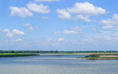 Landscape view small fishing boat on the coast after fishing by fishermen in a small village. It is a small local fishery. Blue sky, white clouds, clear weather.