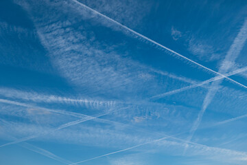 Pattern of several aircraft contrails in the blue sky - obrazy, fototapety, plakaty