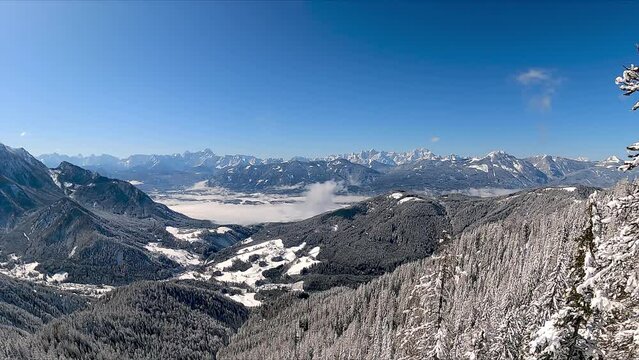 Panoramic view of cold winter wonderland landscape seen from the Bleiberg Erzberg mountains, Gailtal Alps, Carinthia, Austria, Europe. Looking at Karavanks (Karawanken) and Dobratsch Villach Alps