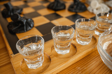 Traditional Georgian dish, khinkali Kalakuri, on wooden table, chess board, rustic, side view, black and light dough, playing chess. Selective focus, side view. Meat and cheese dishes	