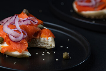 A bagel with cream cheese, capers, red onion, and smoked salmon