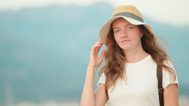 Portrait of charming young tourist woman on the Mediterranean coast. Attractive red-haired girl walking by the sea shore. The concept of natural beauty