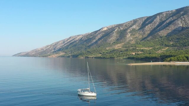 White yacht at sunrise near Golden Horn beach, island of Brac, Croatia.