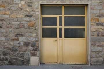 old beige metal door in building with a brick wall, space for text, 