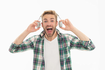 Surprised man taking off headphones for music isolated on white studio