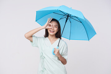 Happy Asian woman standing and holding blue umbrella isolated on white background,  life insurance...