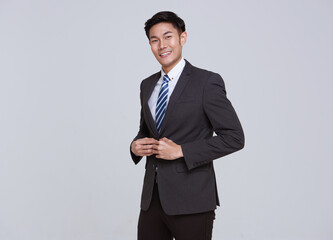 Smiling young handsome southeast Asian businessman in white studio isolated background.