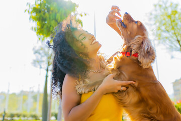 beautiful young woman with long dark curly hair with american cocker dog outdoors