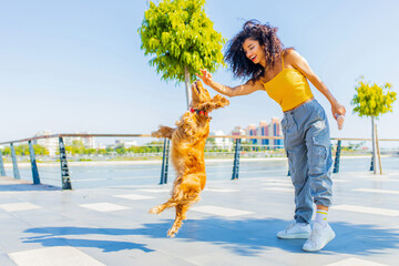 beautiful young woman with long dark curly hair with american cocker dog outdoors
