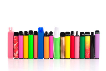 Row of many colorful disposable electronic cigarettes of different shapes on a white background....