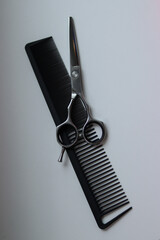 scissors and  on a white background.black comb and silver scissors.silver scissors on a white background.barber tools.hairdresser