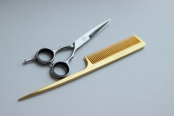 scissors and comb on white background.gold comb and silver scissors.silver scissors on white background.barber tools.hairdresser.gold scissors.