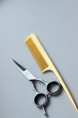 scissors and comb on white background.gold comb and silver scissors.silver scissors on white background.barber tools.hairdresser.gold scissors.