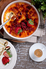 creme brulee with strawberry served in a dish isolated n wooden table top view
