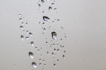 Rainy day raindrops on window as relaxing background texture for autumn and fall season shows rain and water droplets splashing on window surface with rainy weather texture in depression mood