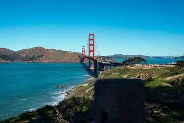 Low-angle closeup of a Golden Gate bridge with a blue sky and river view California, US
