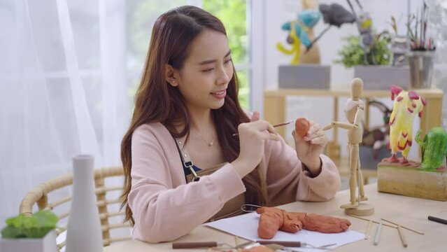 Young Asian girl making a sculpture with modeling clay at home .hobby clay sculpt concept