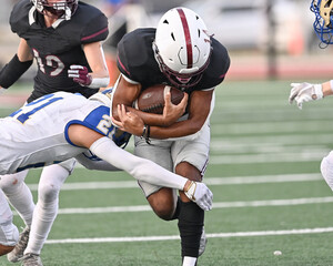 Young athletic tackle football player running hard with the football