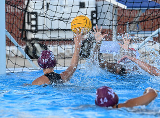 Young teen girls playing a competitive game of waterpolo