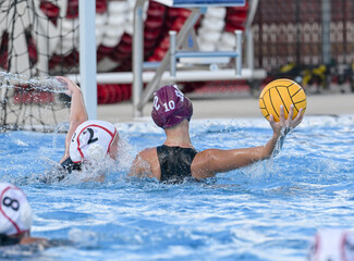 Young teen girls playing a competitive game of waterpolo