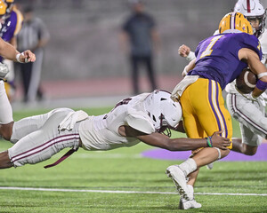Young athletic tackle football player making an exceptional play during a game