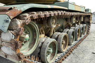 A close up rusty green tank tread.