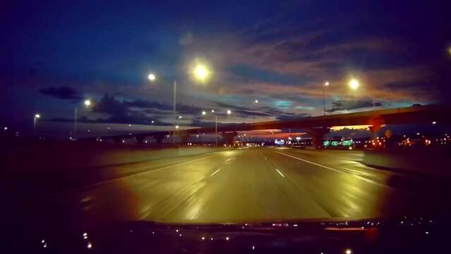 Night driving highway with street lights and dramatic sky, dash camera look and feel.
