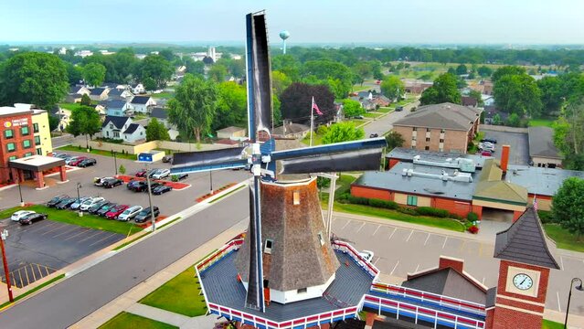 Old fashioned dutch windmill rotating in the wind, moving aerial view.
