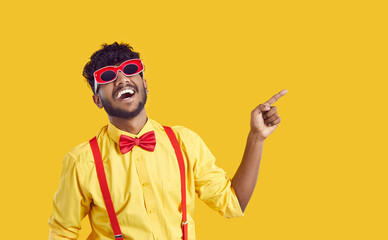 Funny extravagant Indian guy on orange background is advertising new promotion or offering sale....