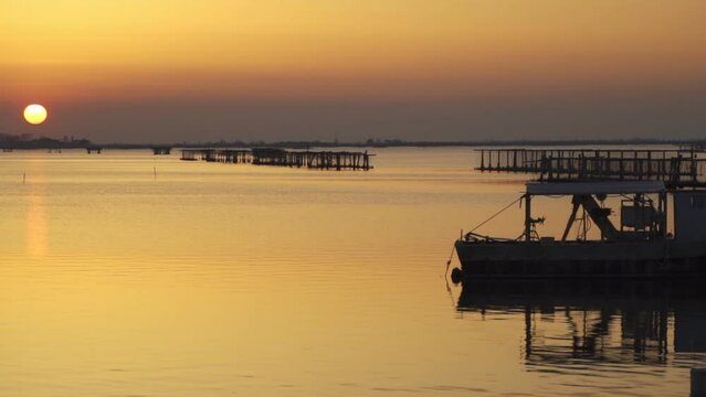 Sunset in Sacca di scardovari, Delta del Po, Comacchio lagoon, sunny day in Veneto, Emilia Romagna, Italy.  Calm and peaceful concept and atmosphere. Sunset Rovigo sea