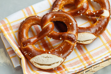 Two traditional soft Octoberfest pretzels in bread basket, close-up