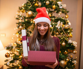 Surprised woman opening a Christmas gift