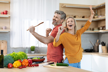 Emoitonal husband and wife having fun while cooking