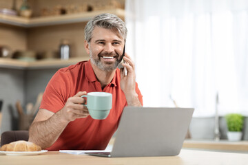 Cheerful handsome man drinking coffee and having conversation