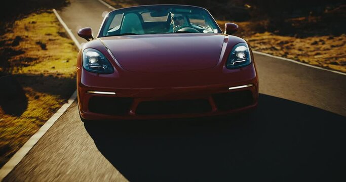 Exhilarating sunset drive, beautiful classic sports car driving on desert road at sunset