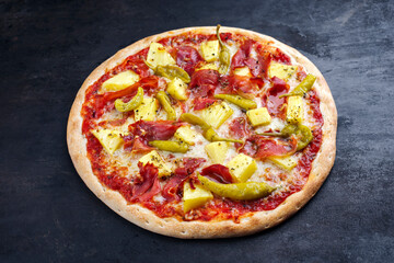 Traditionelle italienische Pizza Hawaii mit Schinken, Ananas und Mozzarella serviert als close-up auf einem alten rustikalen Board mit Textfreiraum 