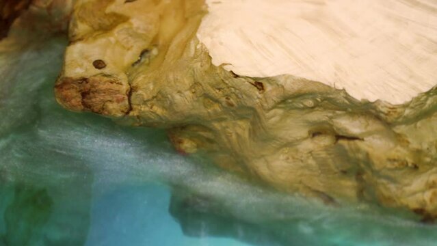 Casting epoxy resin Stabilizing oak wood abstract art background panorama. Texture of wooden table with epoxy resin. Top view of wood for background. Wooden table with epoxy resin blue, close up video