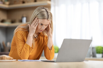 Exhausted blonde woman freelancer working from home