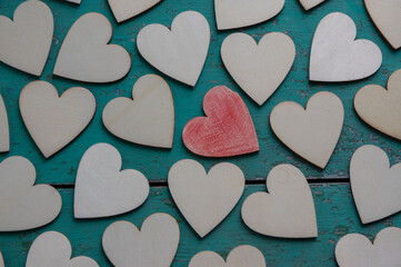 Obraz premium Love Valentines day background, group of light wooden hearts spread on vintage blue green scratched table, flat lay one by one