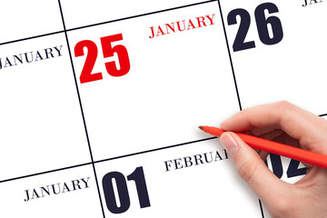 A hand holding a red pen and pointing on the calendar date January 25. Red calendar date, copy...