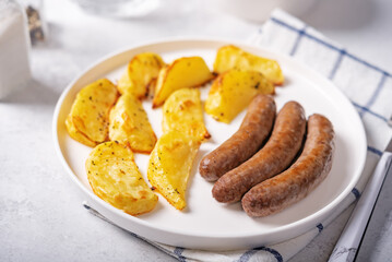 Fried sausages with roasted potato slices