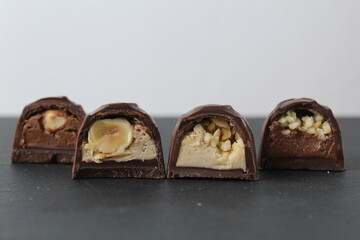 four chocolate case candies with hazelnuts peanut praline chocolate close-up on a gray background with space for copyspace text